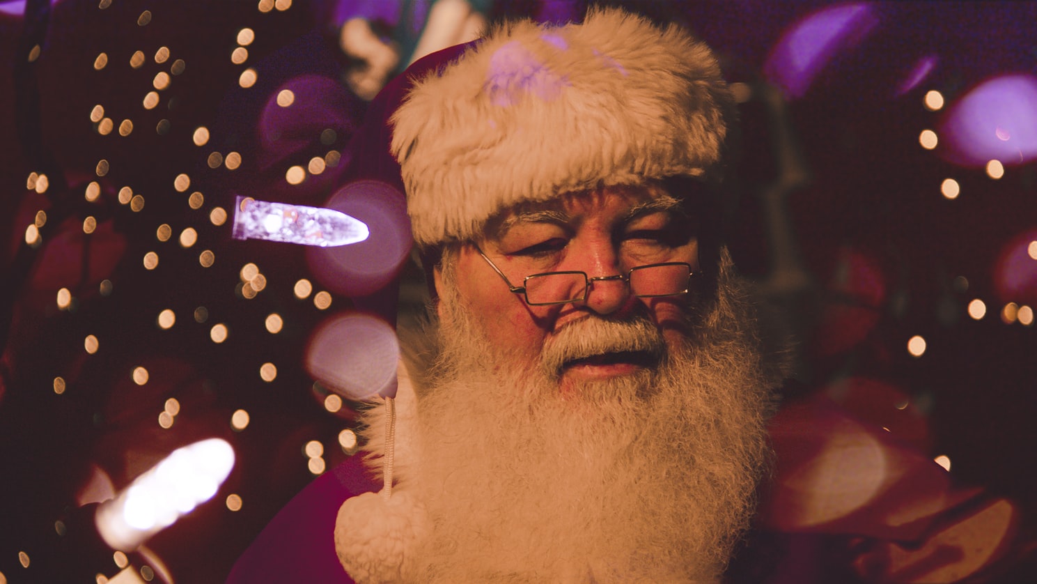 A Sad santa claus in glasses with white beard and red hat