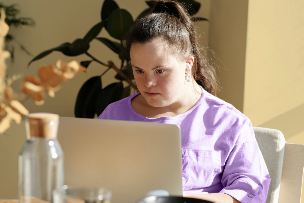 A girl sitting at a desk using a laptop