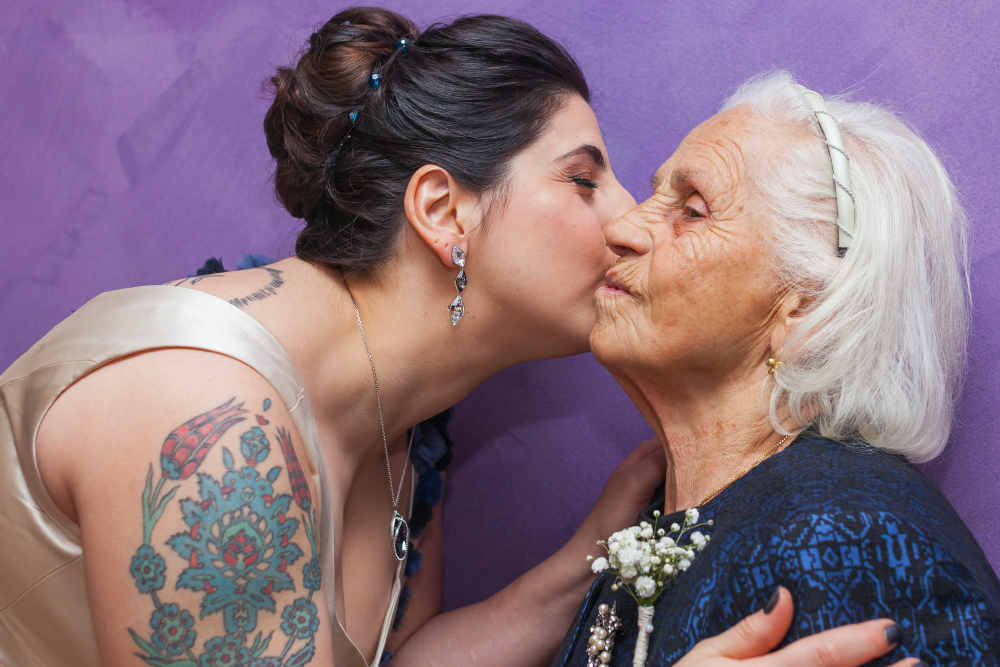 A young woman giving an older woman a kiss on the cheek
