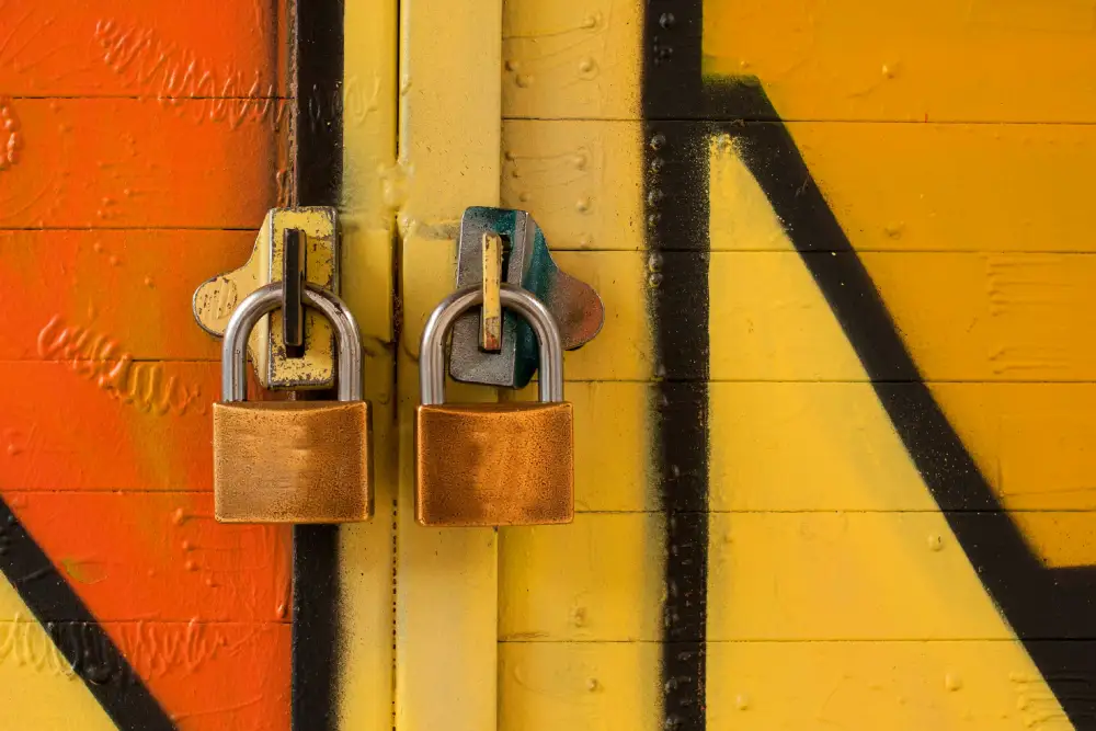 A door with spray-painted red and orange patterns, featuring two locks