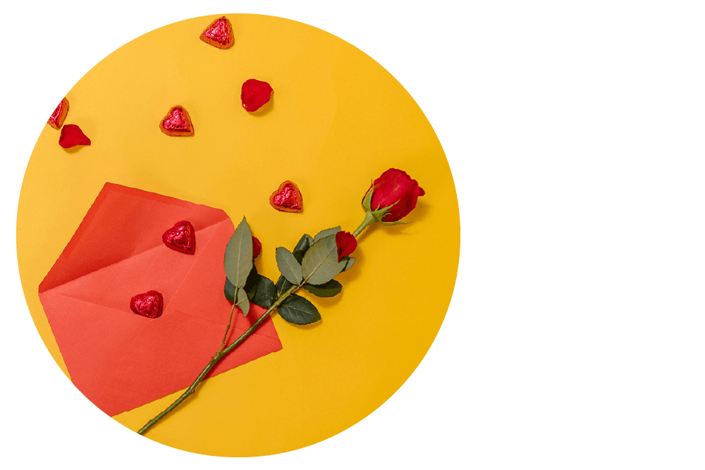 Red envelope and rose with heart chocolates on yellow background.