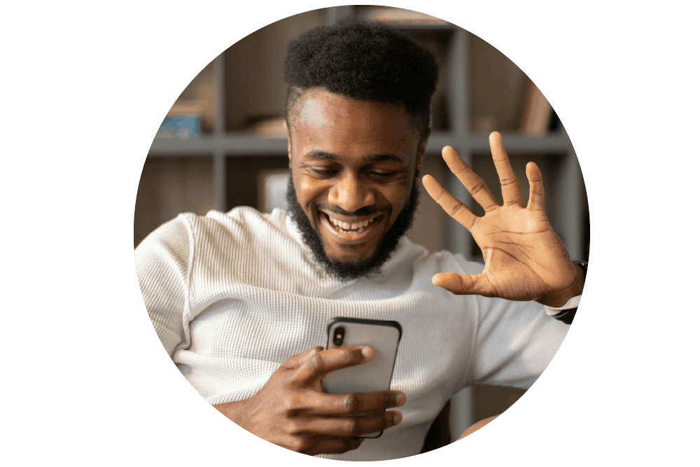 a person holding a white and black mobile phone. They are smiling, with one hand raised and their palm open, fingers spread