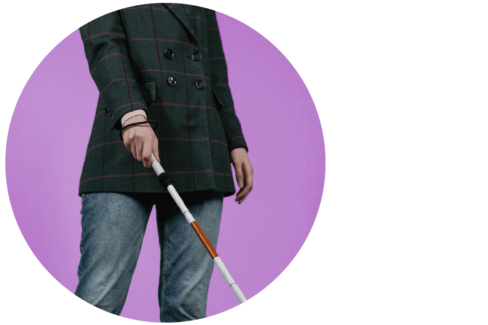 Person standing with a white mobility cane against a purple background