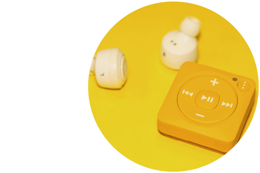 a yellow MP3 player and white earphones against a yellow surface